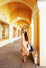 Image showing young pretty smiling woman in hat with bags on shopping at store