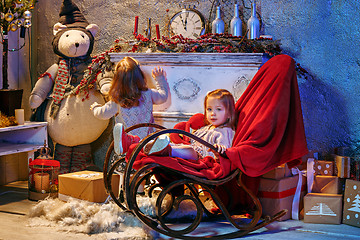 Image showing Little girl and rocking chair near fireplace