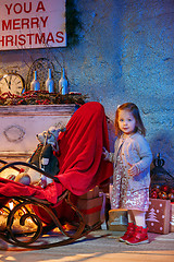 Image showing Little girl and rocking chair near fireplace