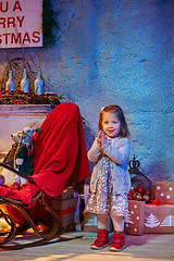 Image showing Little girl and rocking chair near fireplace