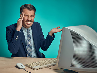 Image showing Sad Young Man Working On computer At Desk