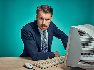 Image showing Sad Young Man Working On computer At Desk