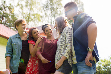 Image showing happy teenage friends hugging at summer garden