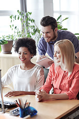 Image showing happy creative team with computer in office