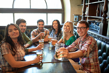 Image showing happy friends drinking beer at bar or pub