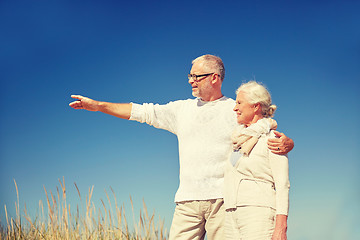 Image showing happy senior couple pointing finger to something