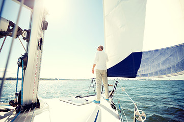 Image showing senior man on sail boat or yacht sailing in sea