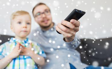 Image showing father and son with remote watching tv at home