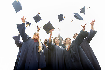 Image showing happy students throwing mortar boards up