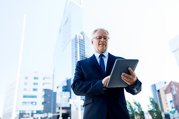 Image showing senior businessman with tablet pc on city street