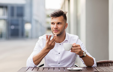 Image showing man with coffee and smartphone at city cafe