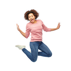 Image showing happy african american woman jumping over white