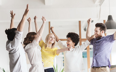 Image showing happy creative team celebrating victory in office