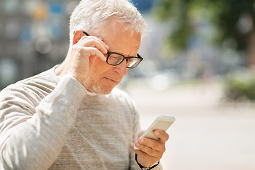 Image showing senior man texting message on smartphone in city