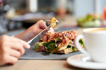 Image showing woman eating prosciutto ham salad at restaurant