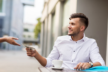 Image showing man with dollar money paying for coffee at cafe