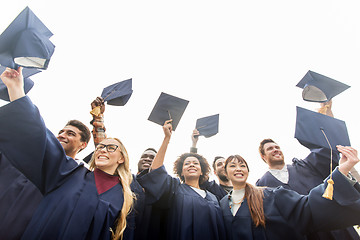 Image showing happy students or bachelors waving mortar boards