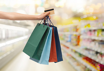 Image showing hand with shopping bags and credit card at store