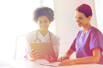 Image showing happy doctors with tablet pc meeting at hospital