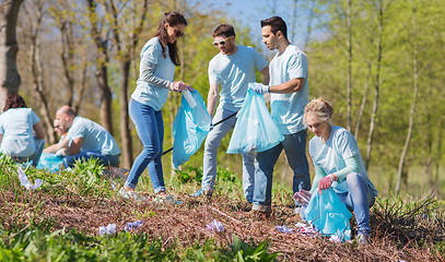 Image showing volunteers with garbage bags cleaning park area