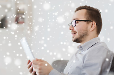 Image showing smiling man working with tablet pc at home