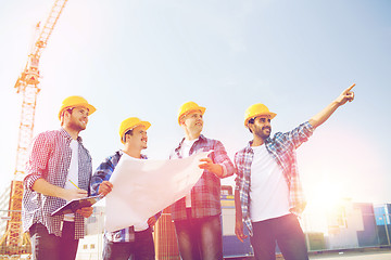 Image showing group of builders with tablet pc and blueprint