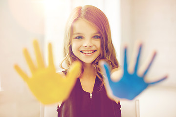 Image showing happy girl showing painted hand palms at home