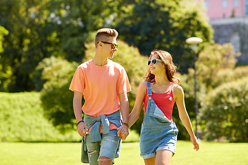 Image showing happy teenage couple walking at summer park