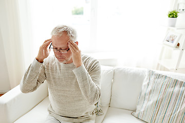 Image showing senior man suffering from headache at home