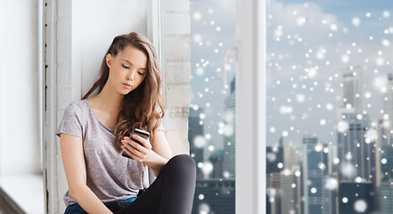 Image showing sad pretty teenage girl with smartphone texting