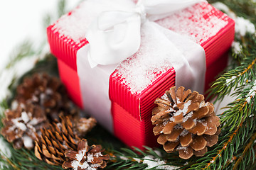 Image showing close up of christmas gift and fir wreath on snow