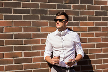 Image showing man with smartphone and coffee cup on city street