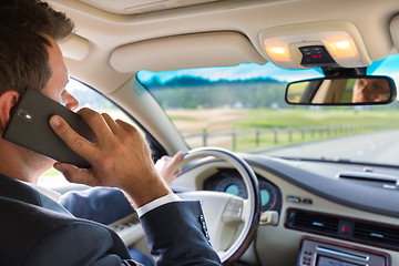 Image showing Man using cell phone while driving