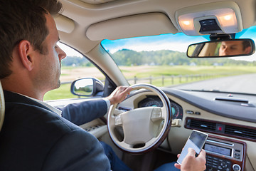 Image showing Man using cell phone while driving