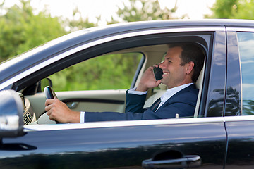 Image showing Man using cell phone while driving.