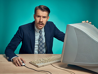 Image showing Surprised Young Man Working On computer At Desk