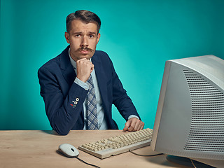 Image showing Sad Young Man Working On computer At Desk