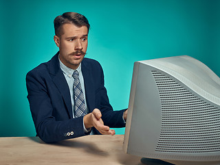 Image showing Sad Young Man Working On computer At Desk