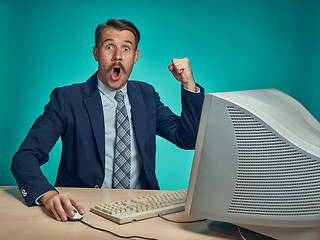 Image showing Surprised Young Man Working On computer At Desk