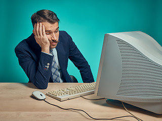 Image showing Sad Young Man Working On computer At Desk