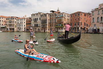 Image showing Group of active tourists stand up paddling on sup boards at Grand Canal, Venice, Italy.