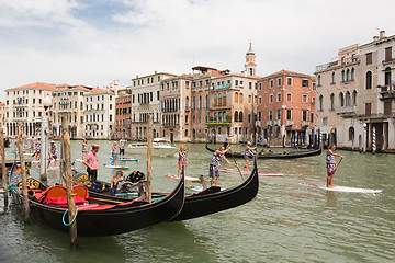 Image showing Group of active tourists stand up paddling on sup boards at Grand Canal, Venice, Italy.