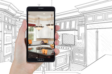 Image showing Hand Holding Smart Phone Displaying Photo of Kitchen Drawing Beh