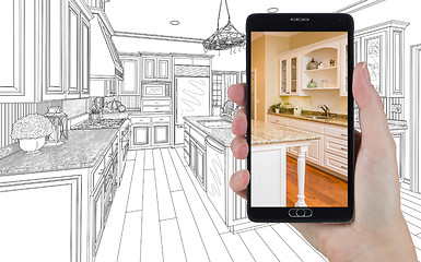 Image showing Hand Holding Smart Phone Displaying Photo of Kitchen Drawing Beh