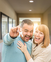 Image showing Couple Holding House Keys Inside Hallway of Their New Home