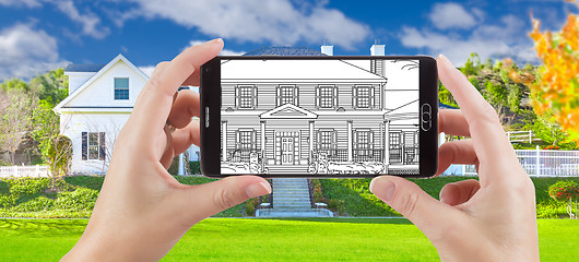 Image showing Hands Holding Smart Phone Displaying Drawing of Home Photo Behin