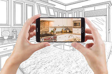 Image showing Hands Holding Smart Phone Displaying Photo of Kitchen Drawing Be