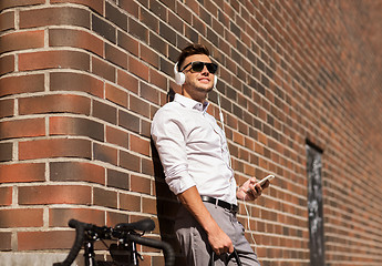 Image showing man with headphones, smartphone and bicycle