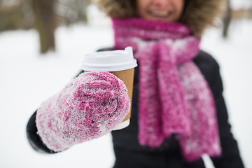 Image showing close up of hand with coffee outdoors in winter