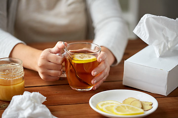 Image showing close up of ill woman drinking tea with lemon